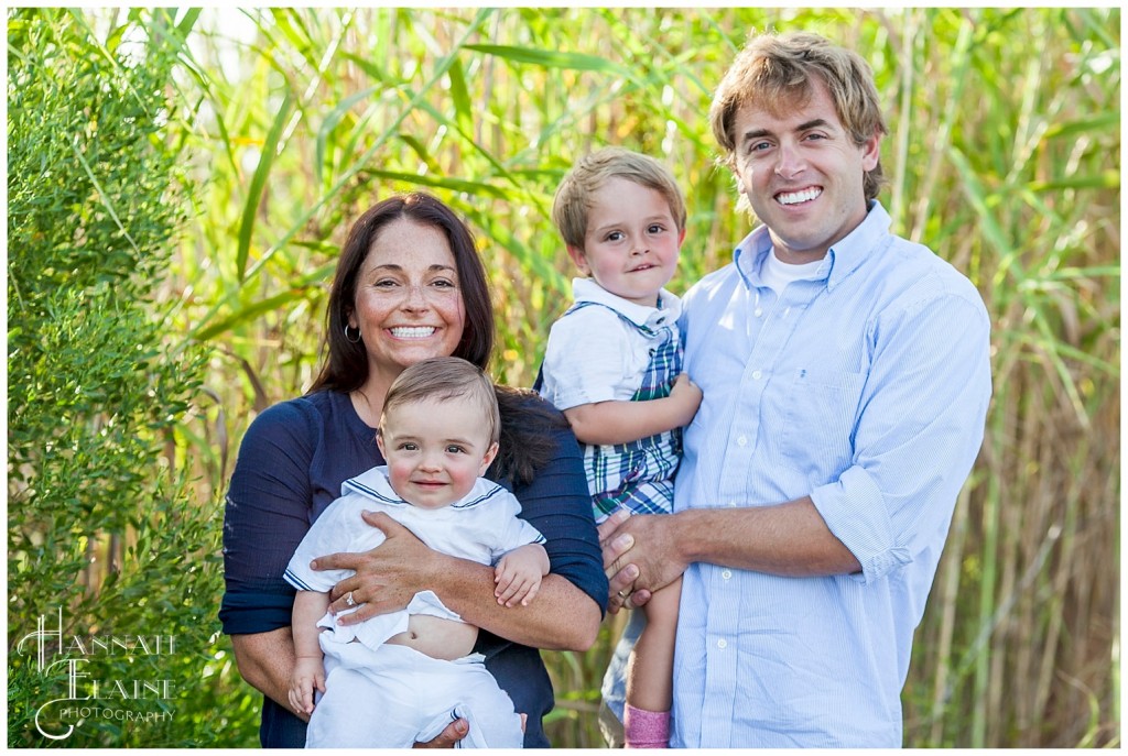 beautiful family stands in the sunset beach grass