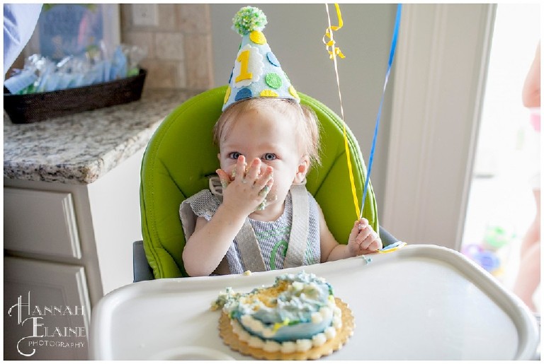 one year old smashes cake into his mouth