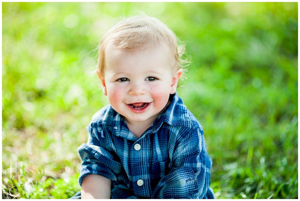 what a happy boy sitting in the grass