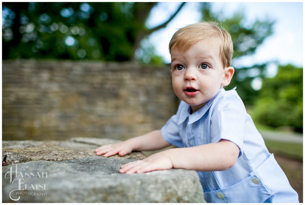 winston climbs up onto an ancient rock wall