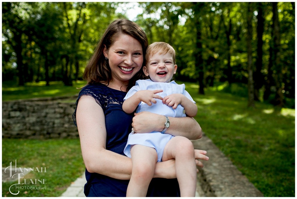 mom holds toddler son as he giggles