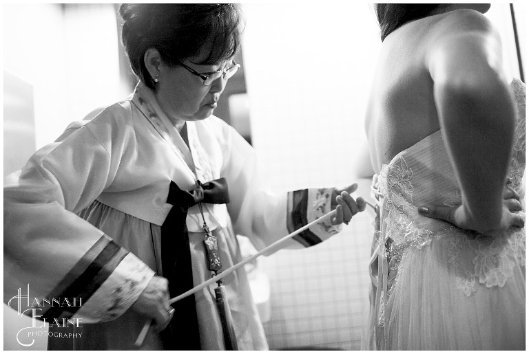korean mother of the bride laces up the back of the dress