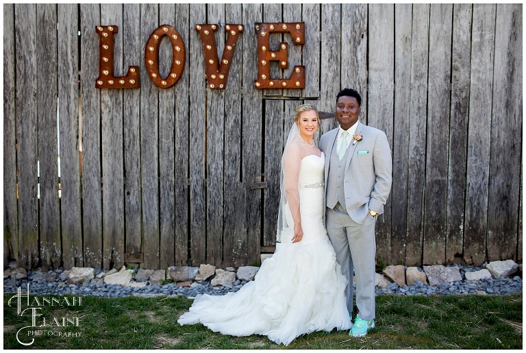 couple in front of love marquee barn