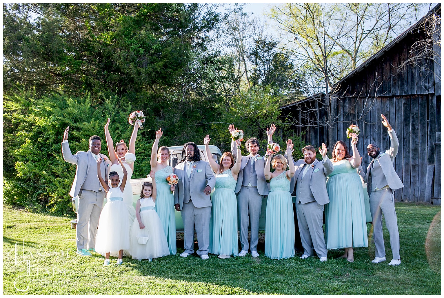 bridal party on vintage truck in front of the barn