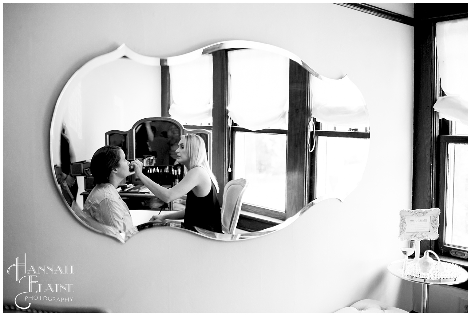 bride gets her makeup done in mirror reflection