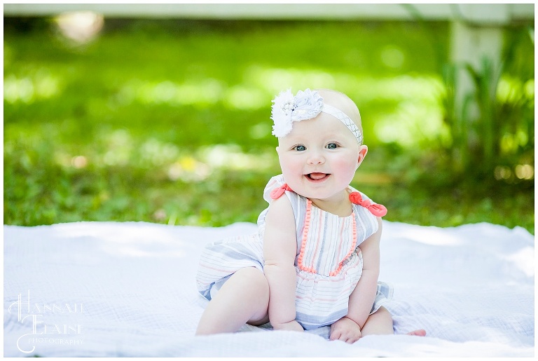 sweet olivia smiles on a blanket in the grass at gravel road traditions