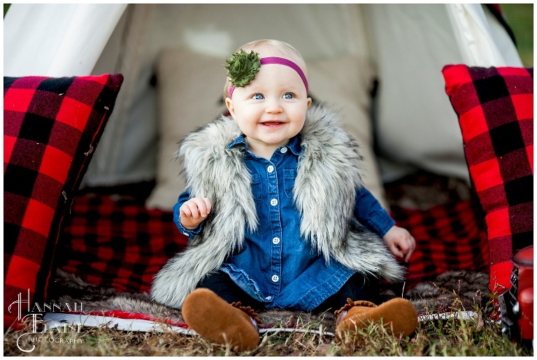 little girl in fur vest sits in a christmas themed teepee at gravel road traditions