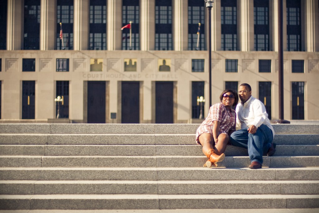 couple poses in front of courthouse in downtown nashville for engagement pics