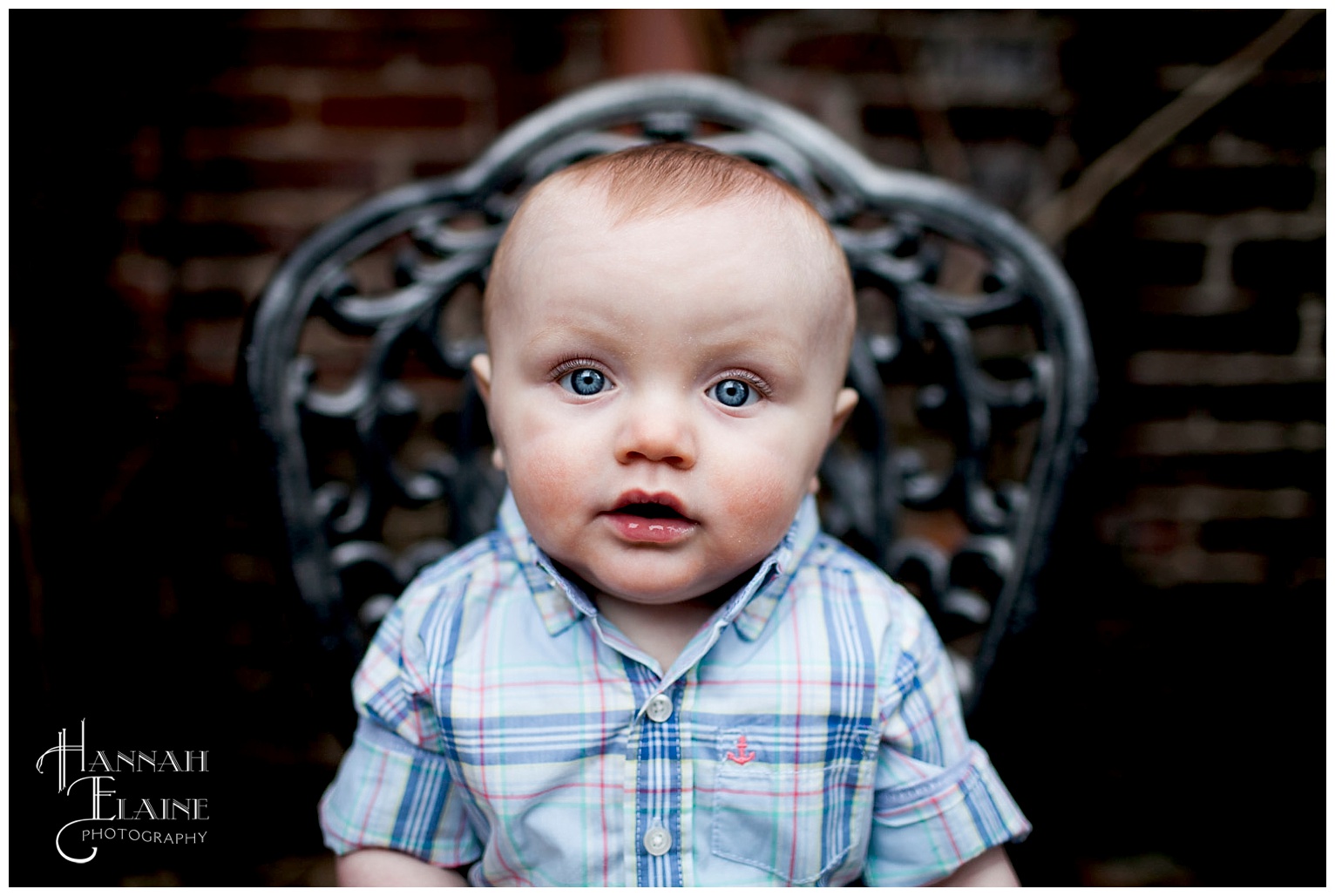 blue eyed baby boy sits on a wrought iron garden chair