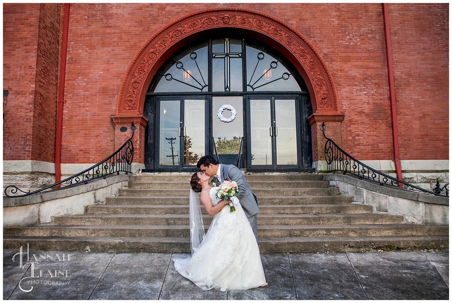 groom gives his bride a foot poppin kiss in front of the chapel